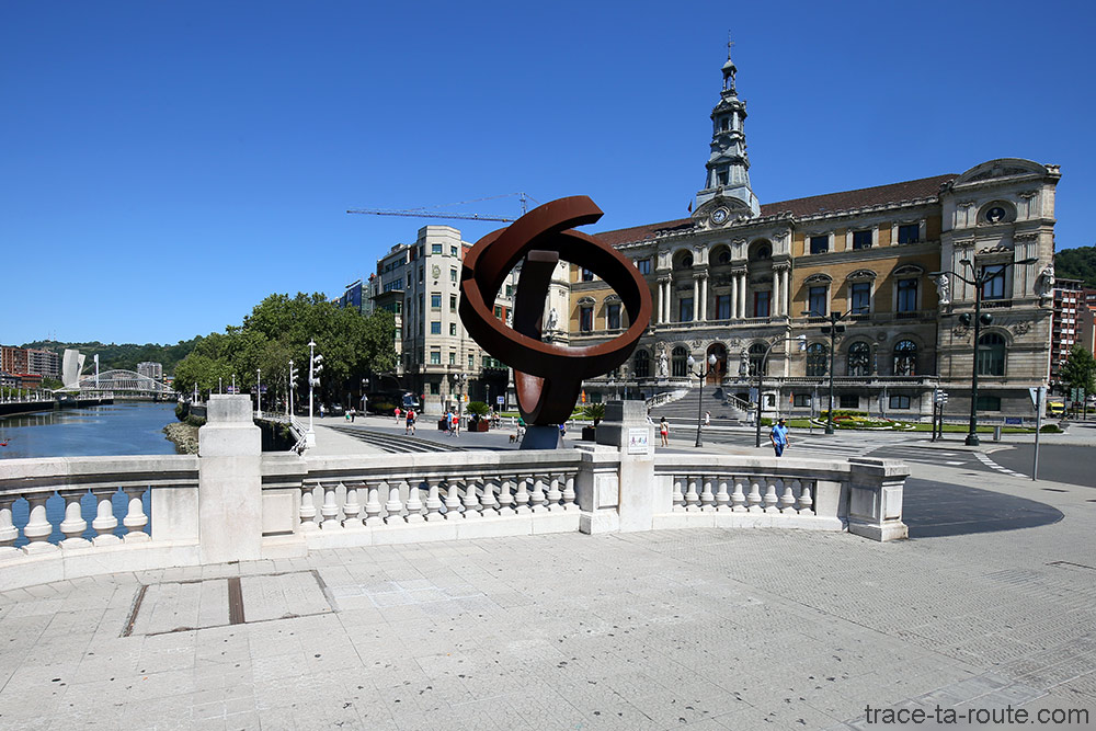 Sculpture de Jorge Oteiza devant l'Hôtel de Ville Mairie de Bilbao avec le fleuve Nervion et Zubizuri en fond