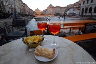 Aperitivo Apérol Spritz sur la terrasse du Caffè Rossini sur le Canal Grande de Trieste avec l'Église Sant'Antonio Nuovo en fond