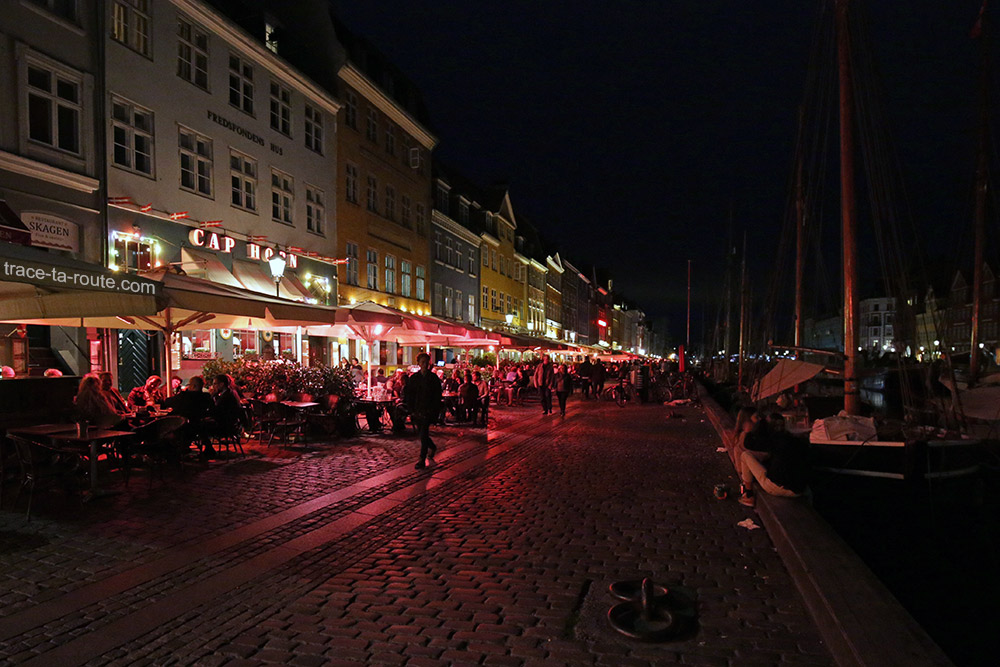 Canal de Nyhavn à Copenhague by night : terrasses sur le quai le soir et façades colorées (Danemark)