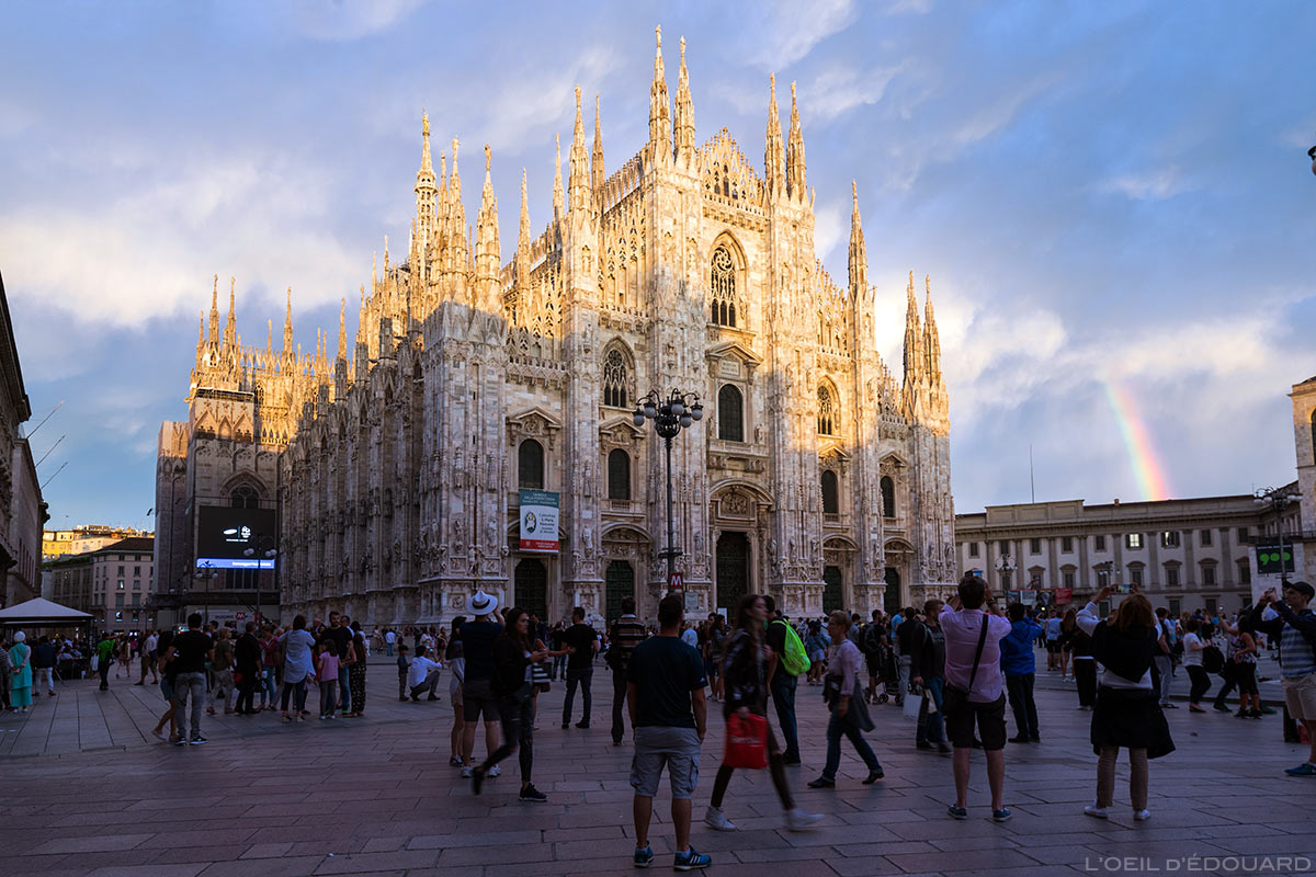 La façade de la Cathédrale Duomo de Milan, illuminée par une éclaircie avec un arc-en-ciel - Duomo Milano © L'Oeil d'Édouard